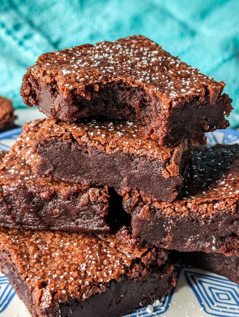 stack of brownies with a bite missing from the top one.