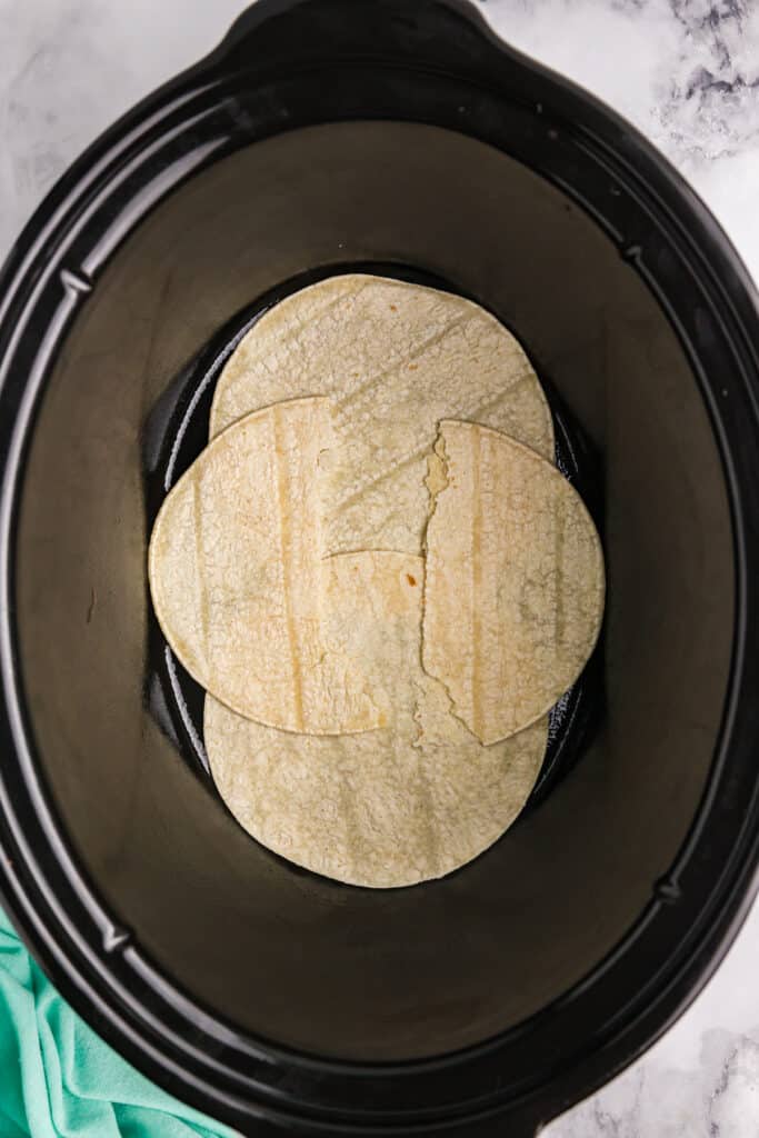 a layer of torn tortillas in a crockpot.