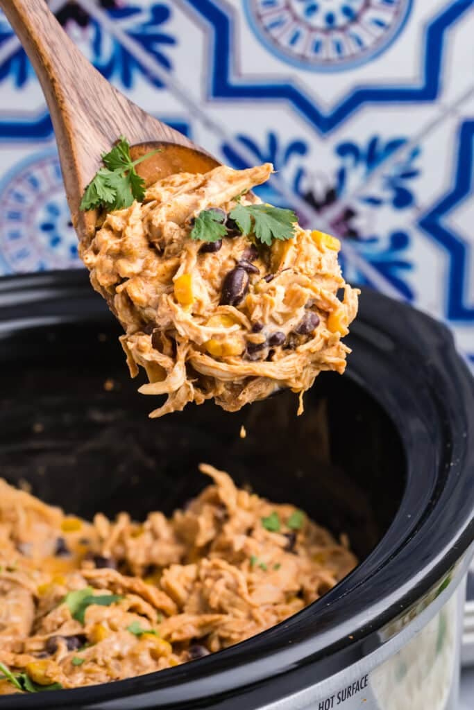 spoon scooping fiesta chicken from a crockpot.