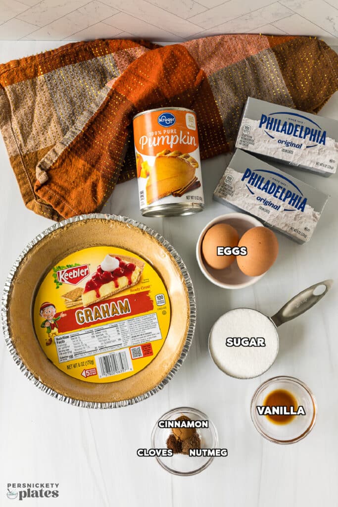 overhead shot of labeled ingredients laid out to make a pumpkin pie cheesecake.