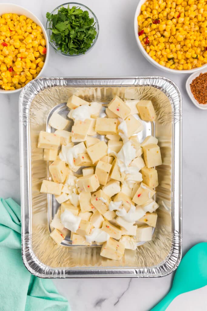 cubed cheeses in a aluminum pan.