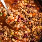 ladle scooping pasta fagioli from a slow cooker.