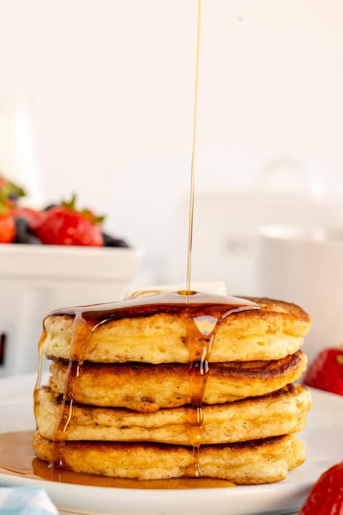 syrup drizzling onto a stack of pancakes.