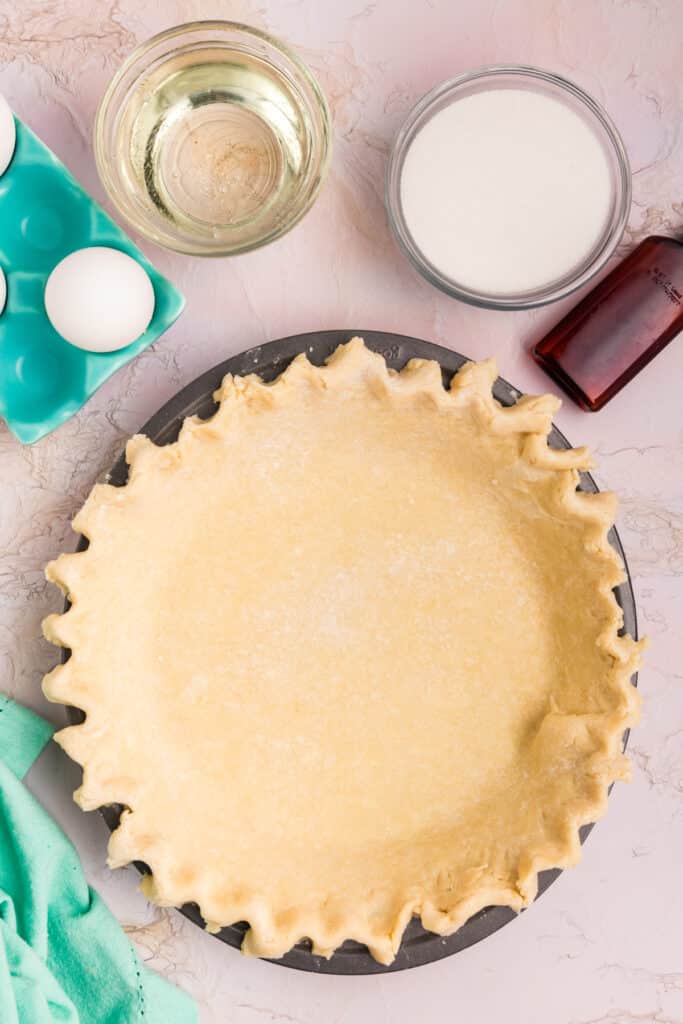 overhead shot of an unbaked pie crust crimped in a plate.
