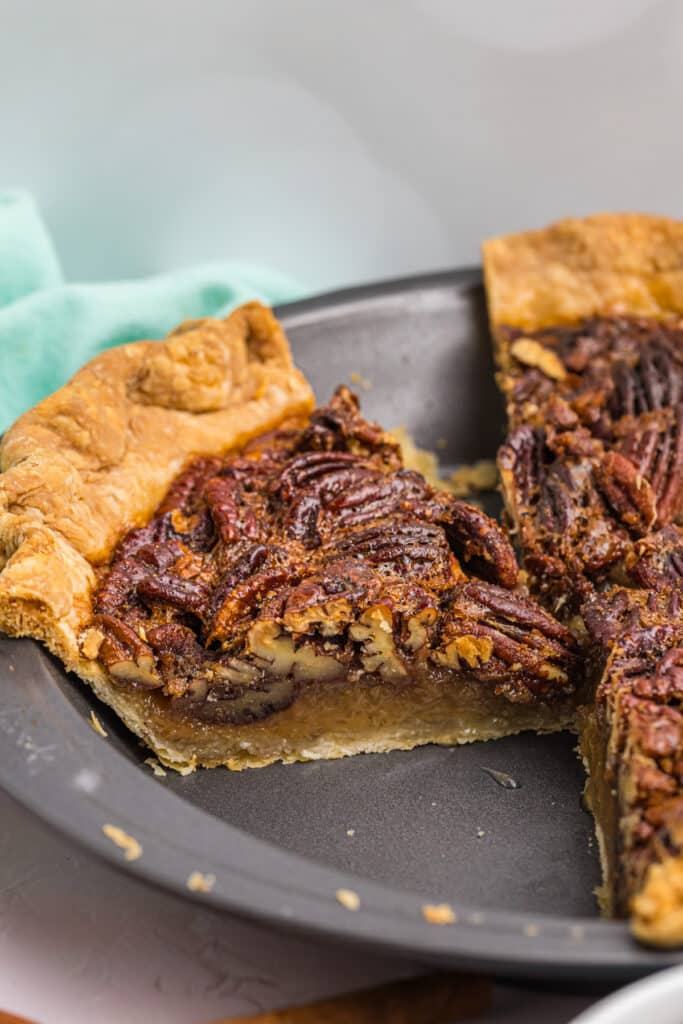 side view of a slice of vintage pecan pie in a pie plate.
