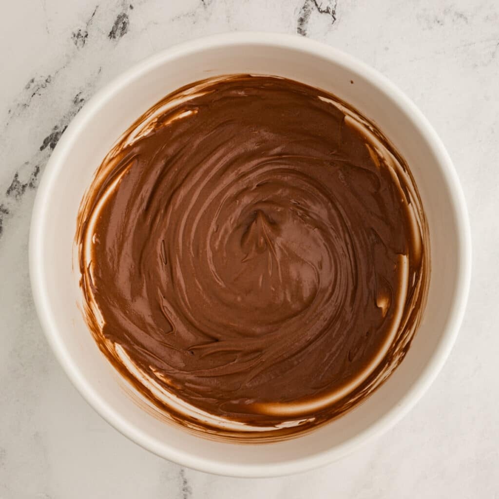 overhead shot of chocolate frosting in a bowl.