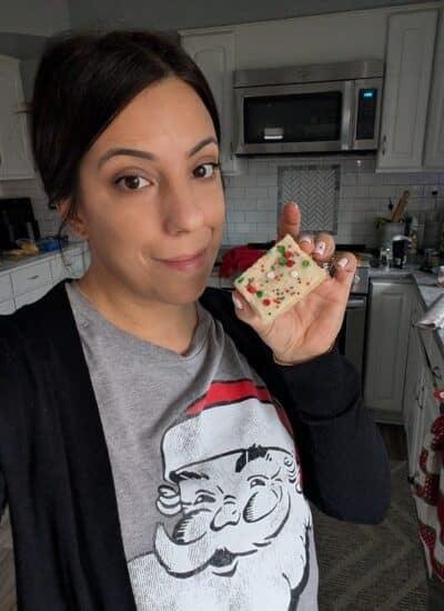 melissa williams persnicketyplates holding a cookie bar wearing a santa shirt.