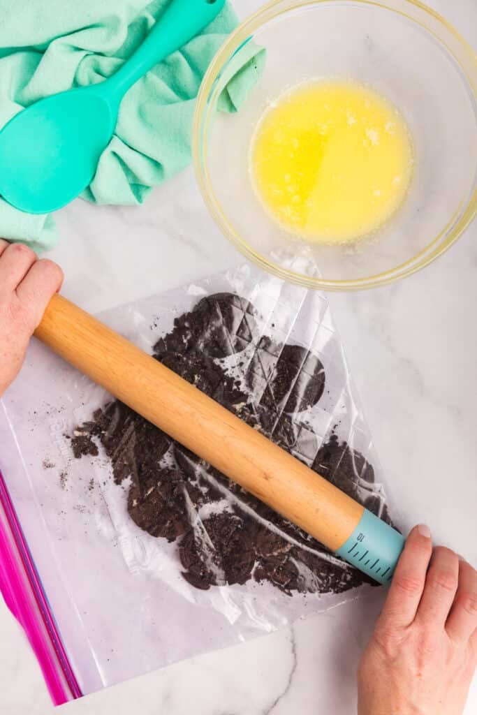 Rolling pin crushing Oreos in a bag
