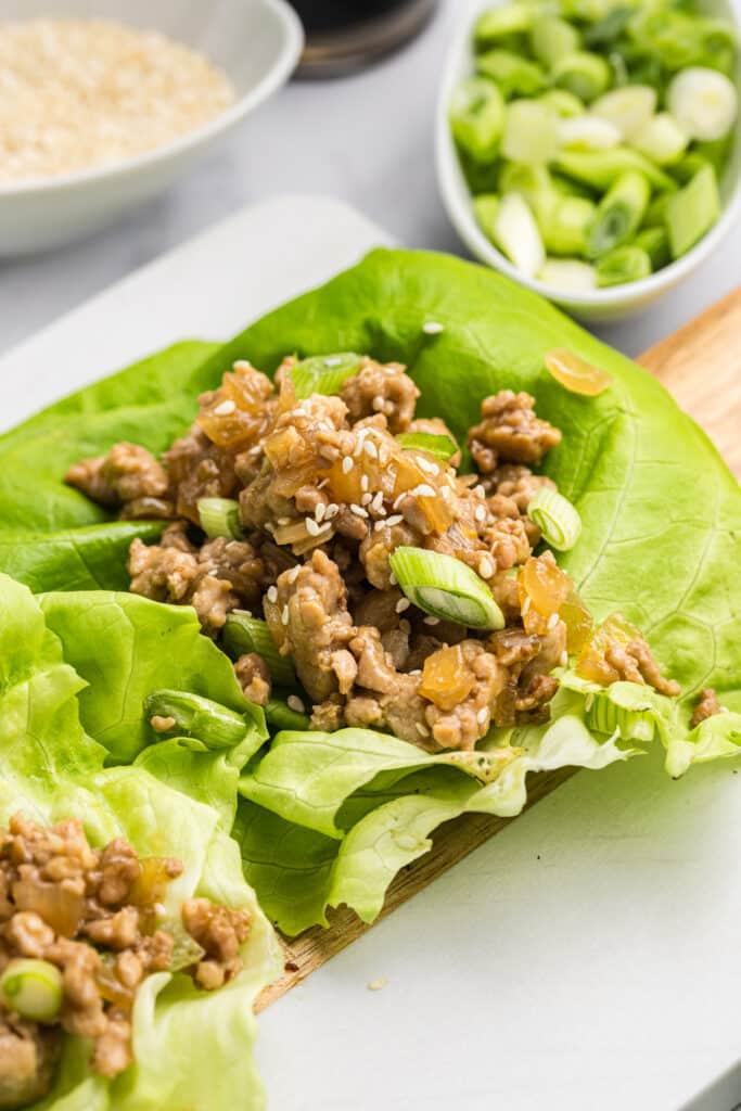 Lettuce wraps filled with chicken mixture and sesame seeds.