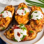 plate of twice baked potatoes topped with sour cream and chives.