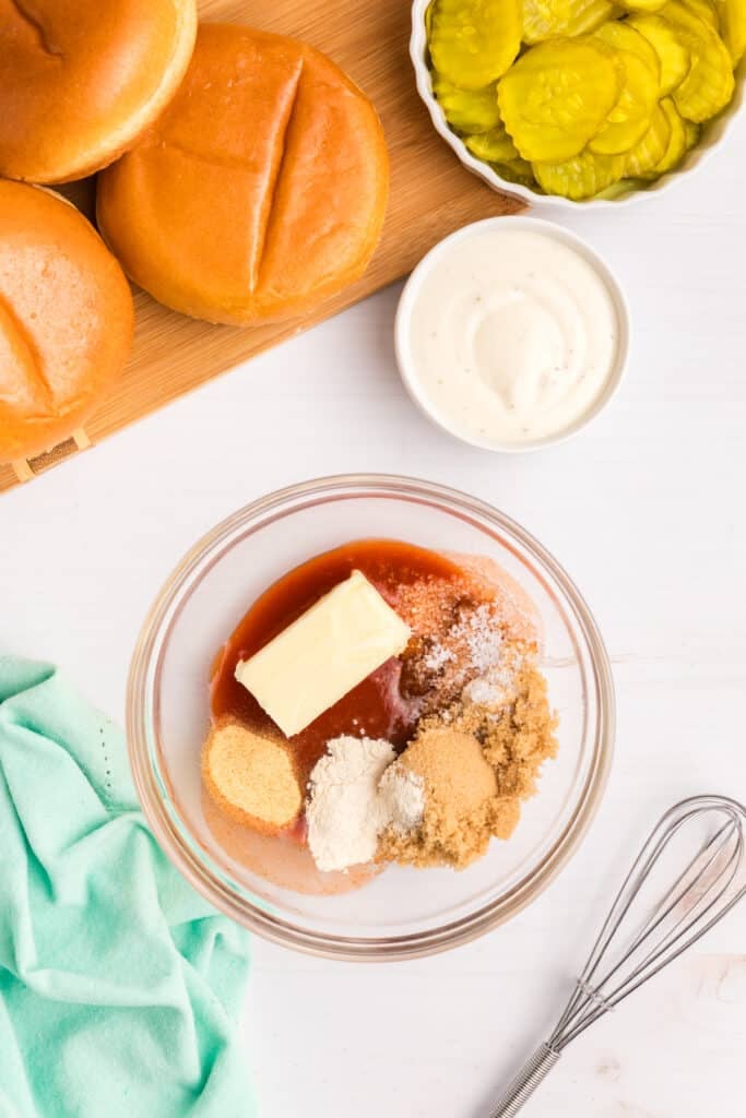 overhead shot of sauce ingredients in a bowl with a whisk.