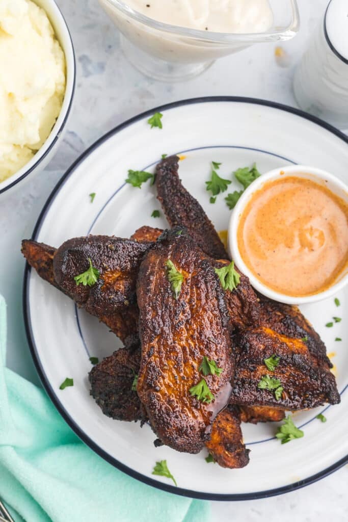 blackened tenders on a platter with mashed potatoes.