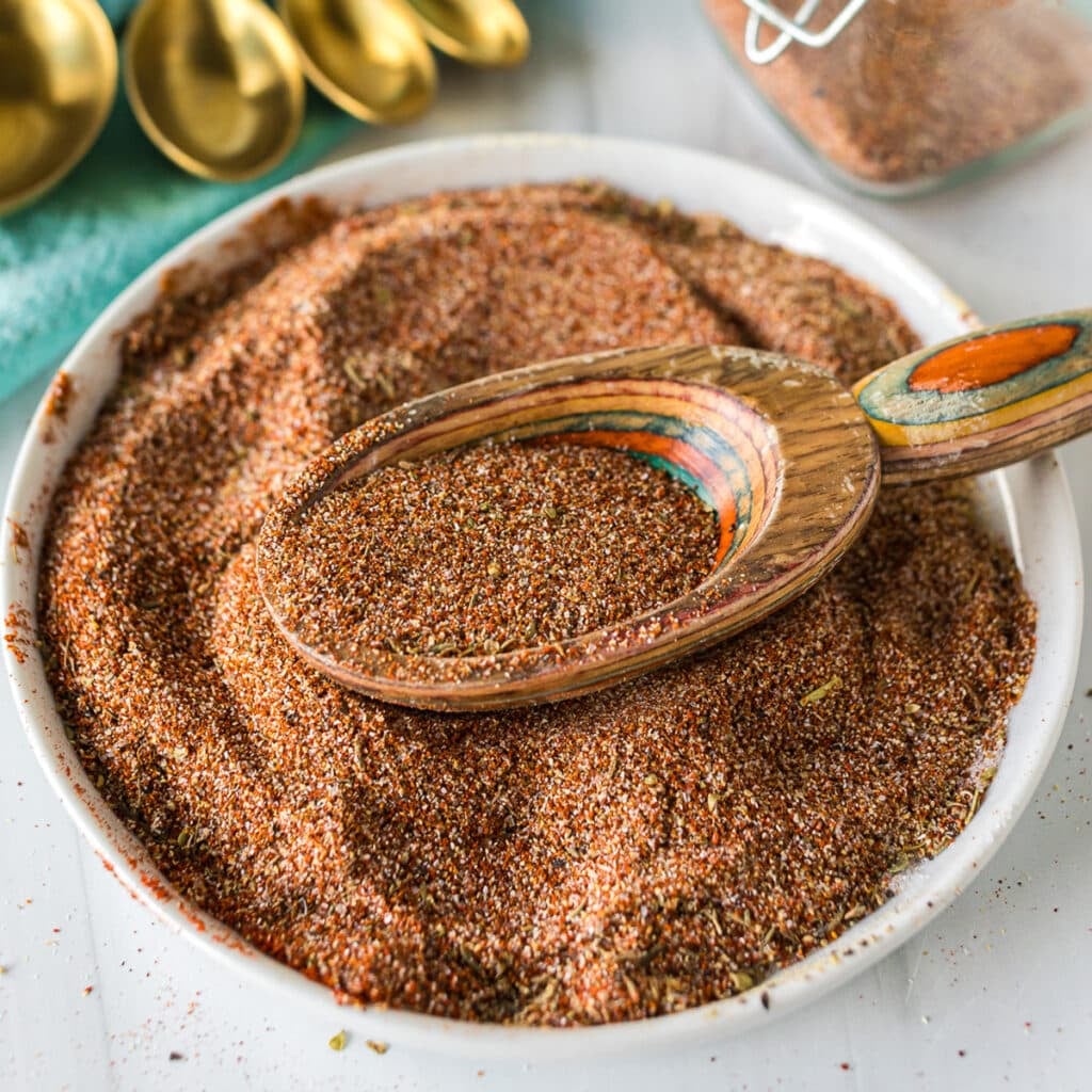 homemade blackened seasoning on a plate with a wooden scoop.