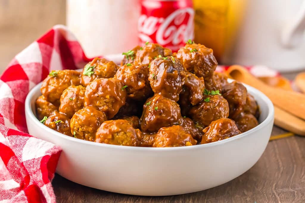 bowl of meatballs with a can of coke in the background.