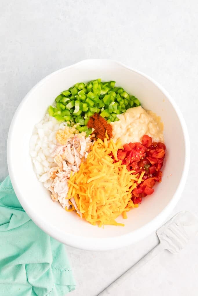 Unmixed casserole ingredients in a white mixing bowl.