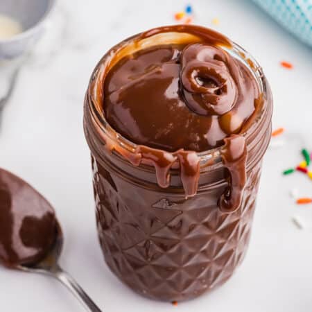 A jar filled with thick homemade hot fudge, dripping down the sides.