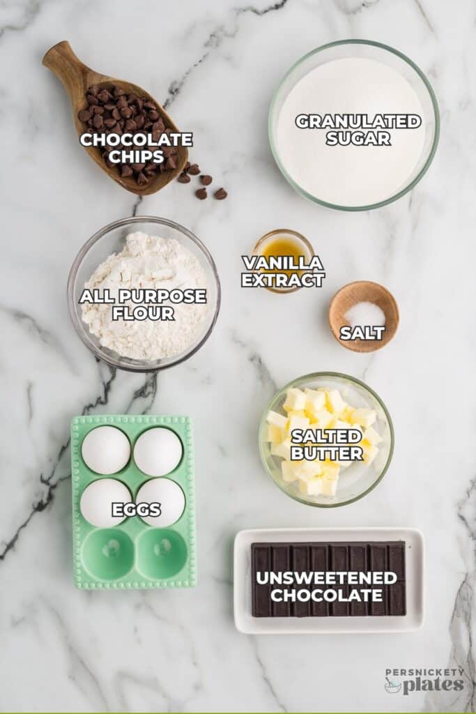 Measured brownie ingredients labeled on a marble countertop.