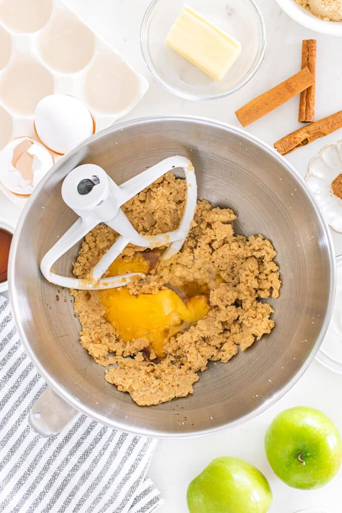 Eggs added to a mixing bowl of brown sugar mixture.