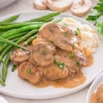 Cube steak with mushroom gravy served with mashed potatoes and green beans.