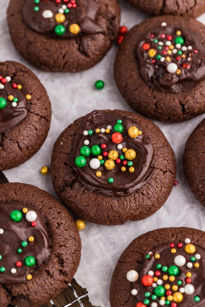 Chocolate cookies topped with chocolate centers and colorful round sprinkles.