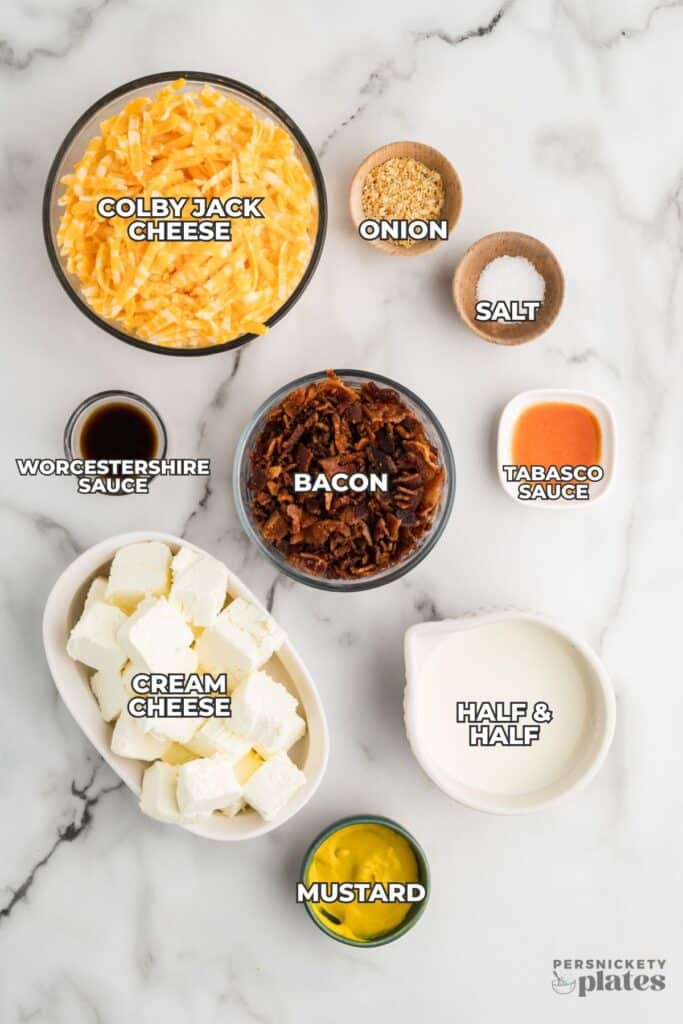 Ingredients for bacon and cheese dip arranged on a marble surface.