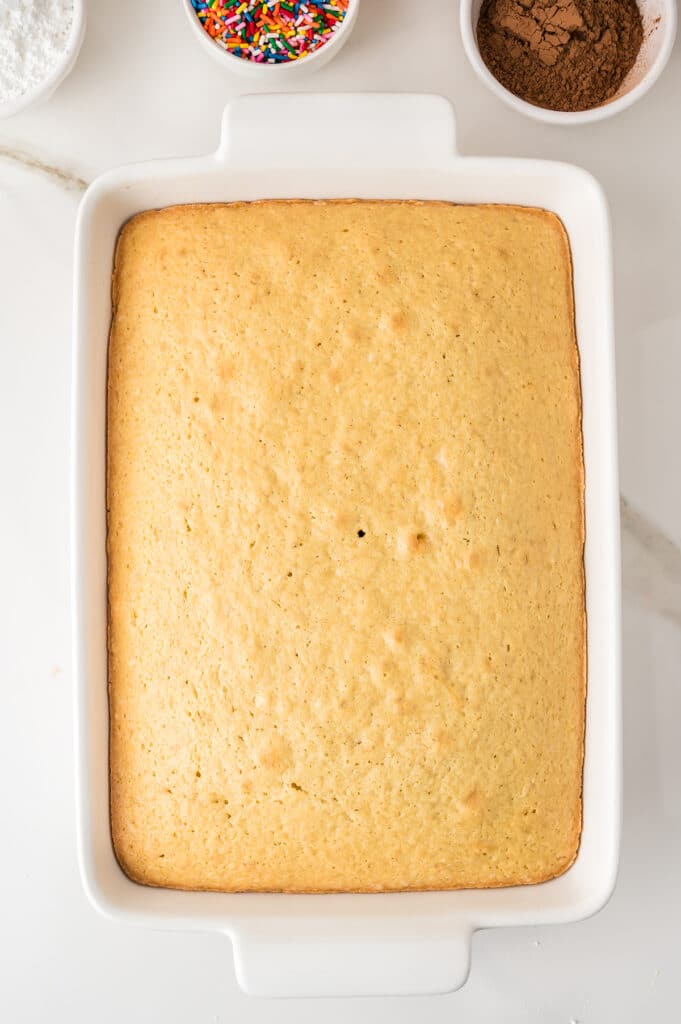 Plain baked yellow sheet cake in a white baking dish.